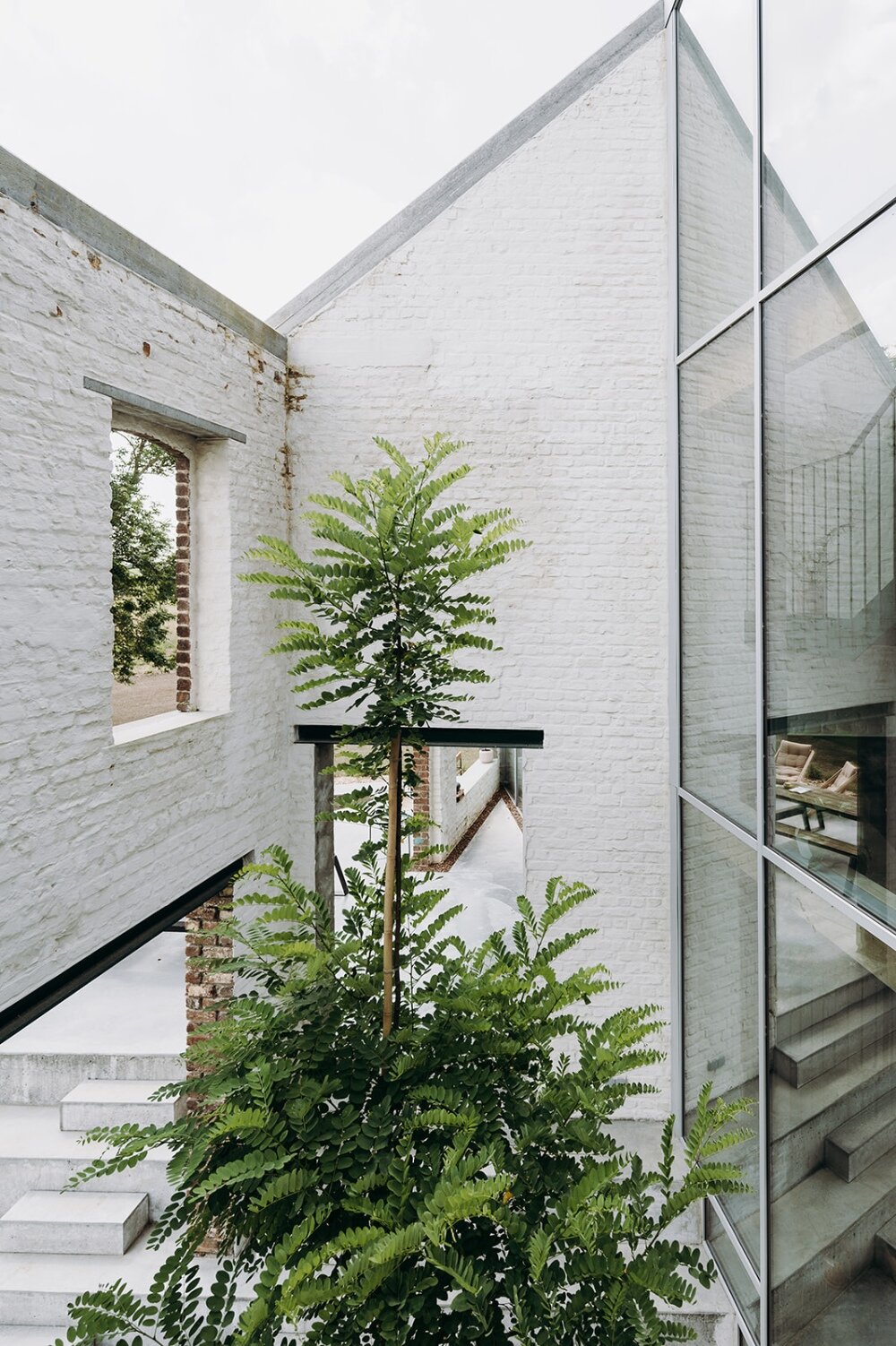 OYO architects carves triangular incision into belgium farmhouse to form luminous courtyard