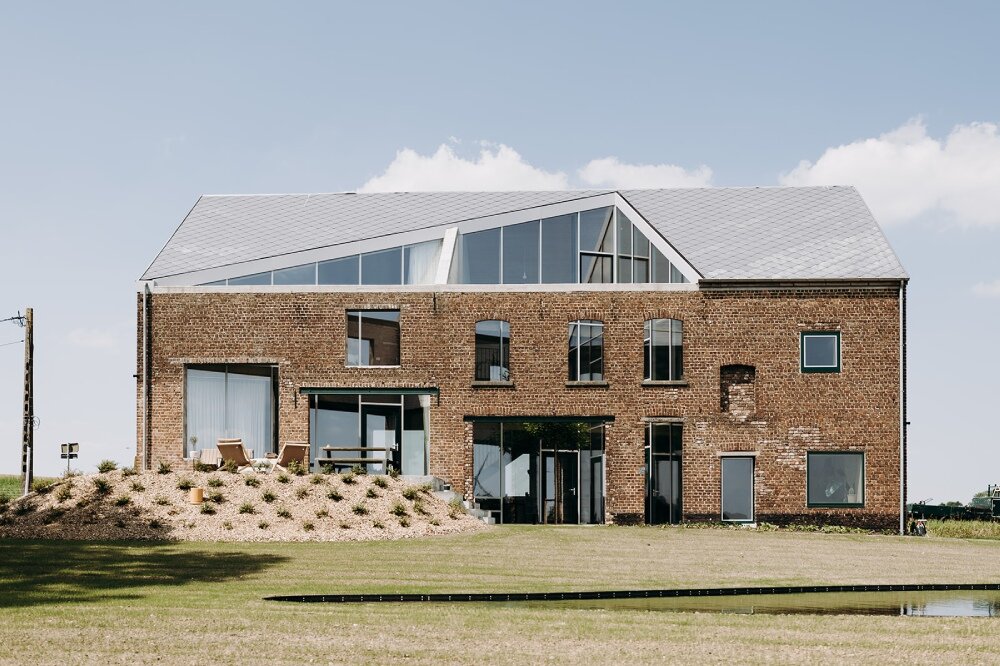 OYO architects carves triangular incision into farmhouse in rural belgium, bringing in light and air