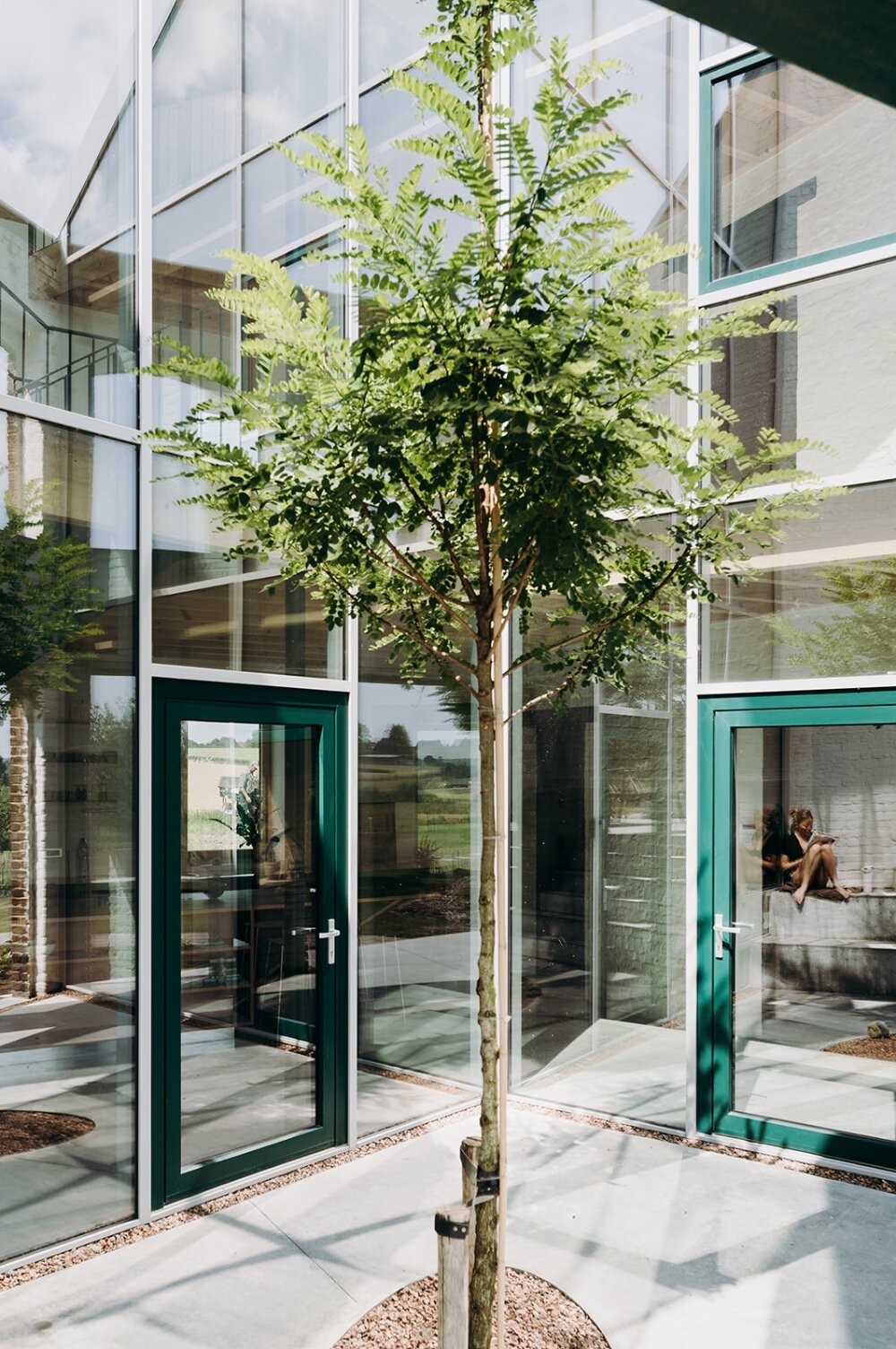 OYO architects carves triangular incision into farmhouse in rural belgium, bringing in light and air