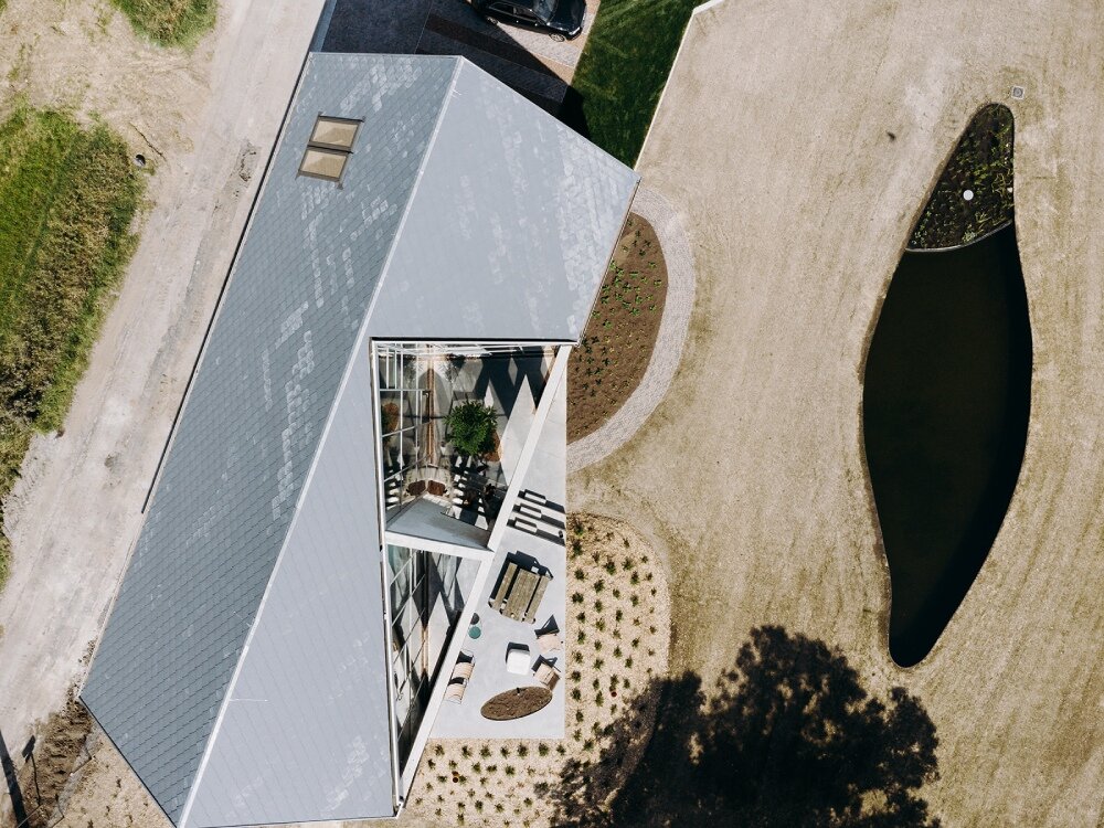 OYO architects carves triangular incision into farmhouse in rural belgium, bringing in light and air