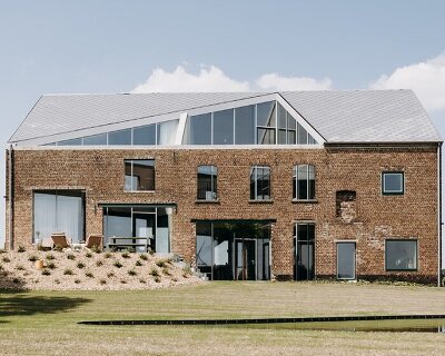 OYO architects carves triangular incision into belgium farmhouse to form luminous courtyard
