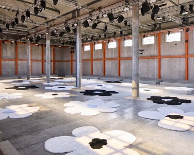 flower carpet islands by AMO bloom across prada's SS26 menswear showcase in milan