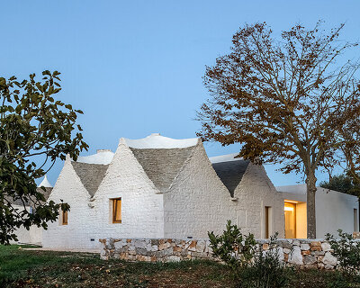 reisarchitettura's L-shaped extension completes traditional stone house with six trulli in italy