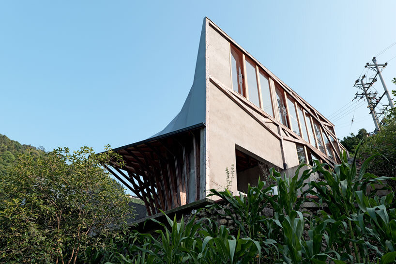 transforming roofscape expands over timber farmhouse in yunnan, china