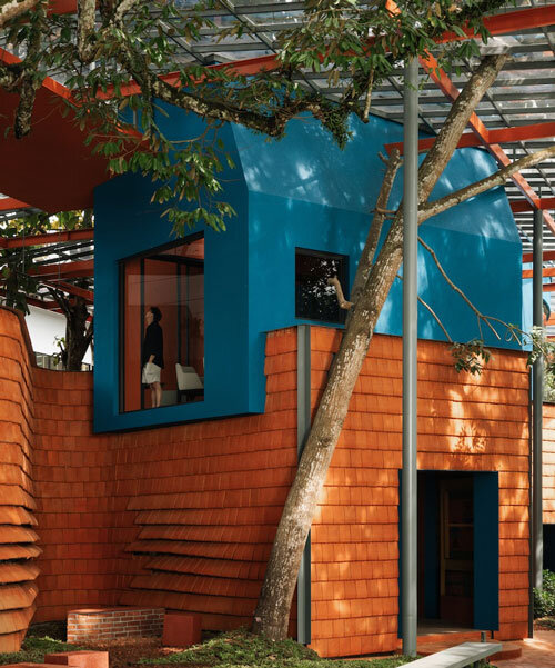 azure blue hues contrast with terracotta tiles on nusa kitchen pavilion's facade in java