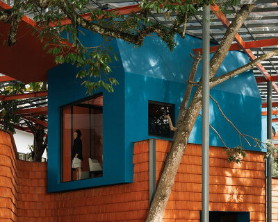 azure blue hues contrast with terracotta tiles on nusa kitchen pavilion's facade in java