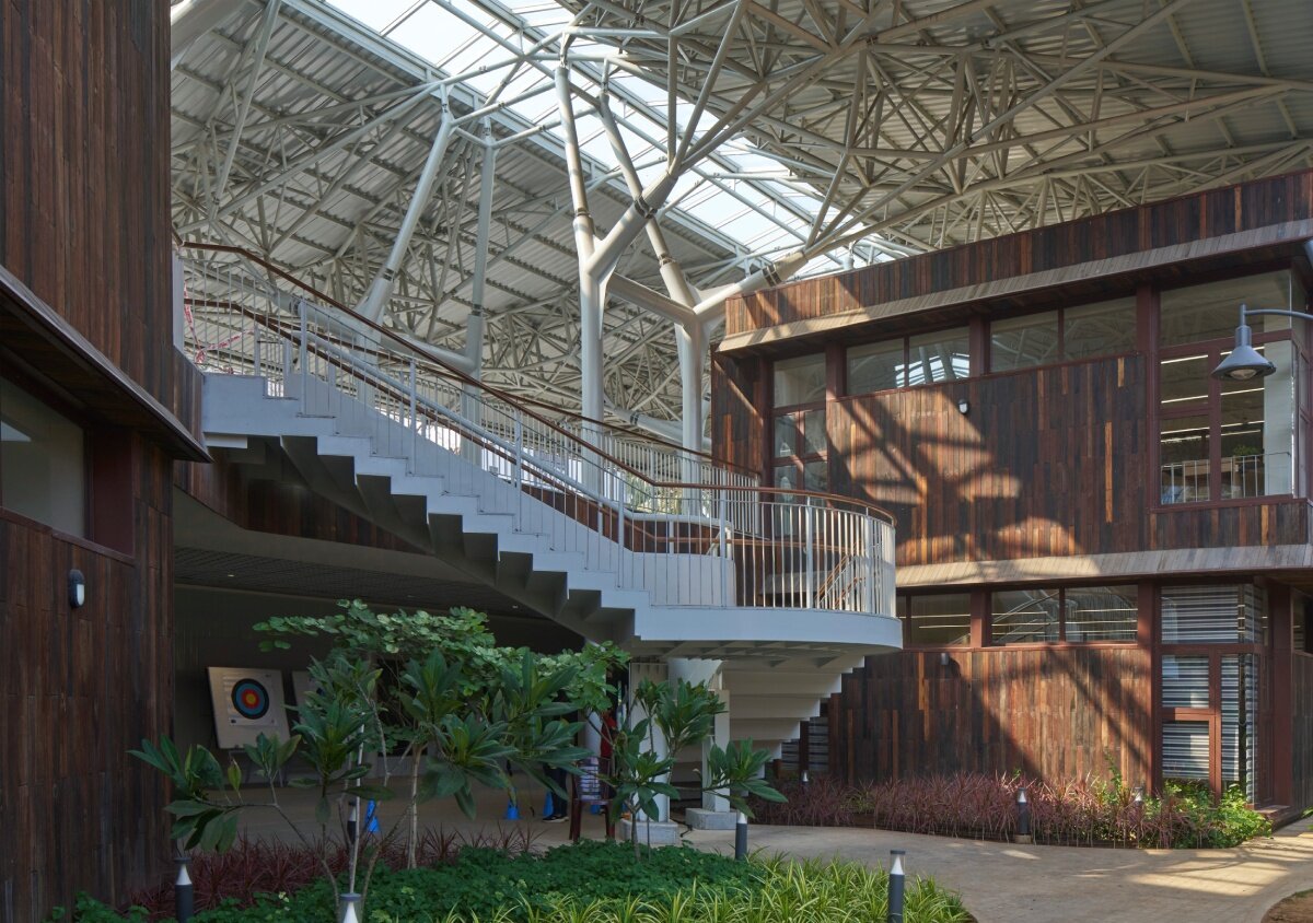 layered red roof sweeps over vastushilpa sangath’s verdant school in chennai, india