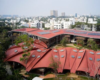 layered red roof sweeps over vastushilpa sangath’s verdant school in chennai, india