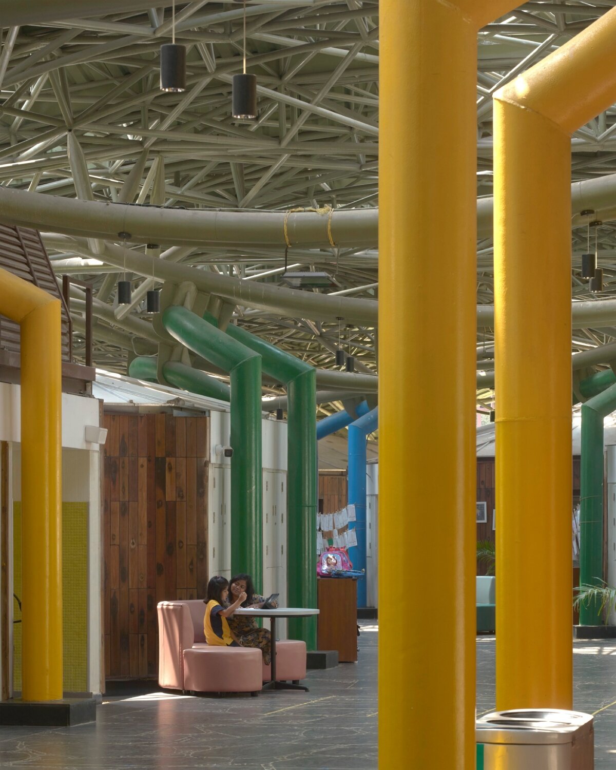 layered red roof sweeps over vastushilpa sangath’s verdant school in chennai, india