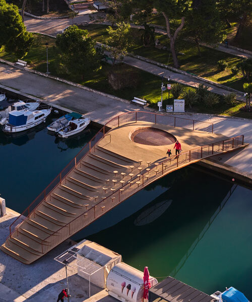slender steel bridge with integrated net seating expands over foša port in croatia
