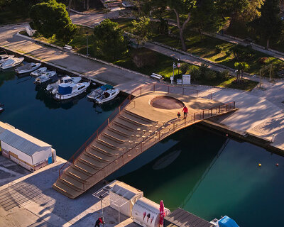 slender steel bridge with integrated net seating expands over foša port in croatia