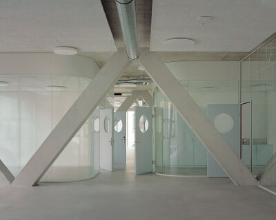 elevated concrete truss frame forms vocational school for construction trades in zurich