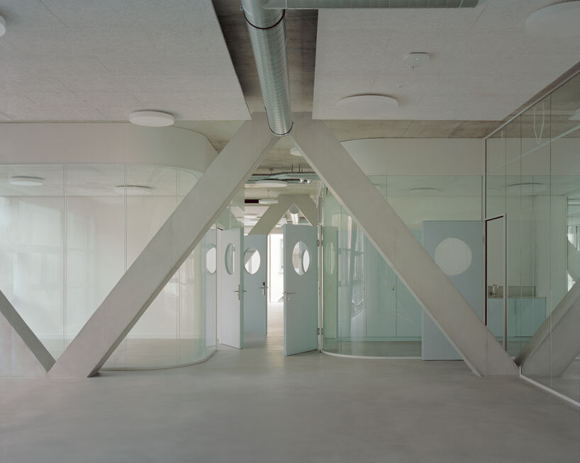 elevated concrete truss frame forms vocational school for construction trades in zurich