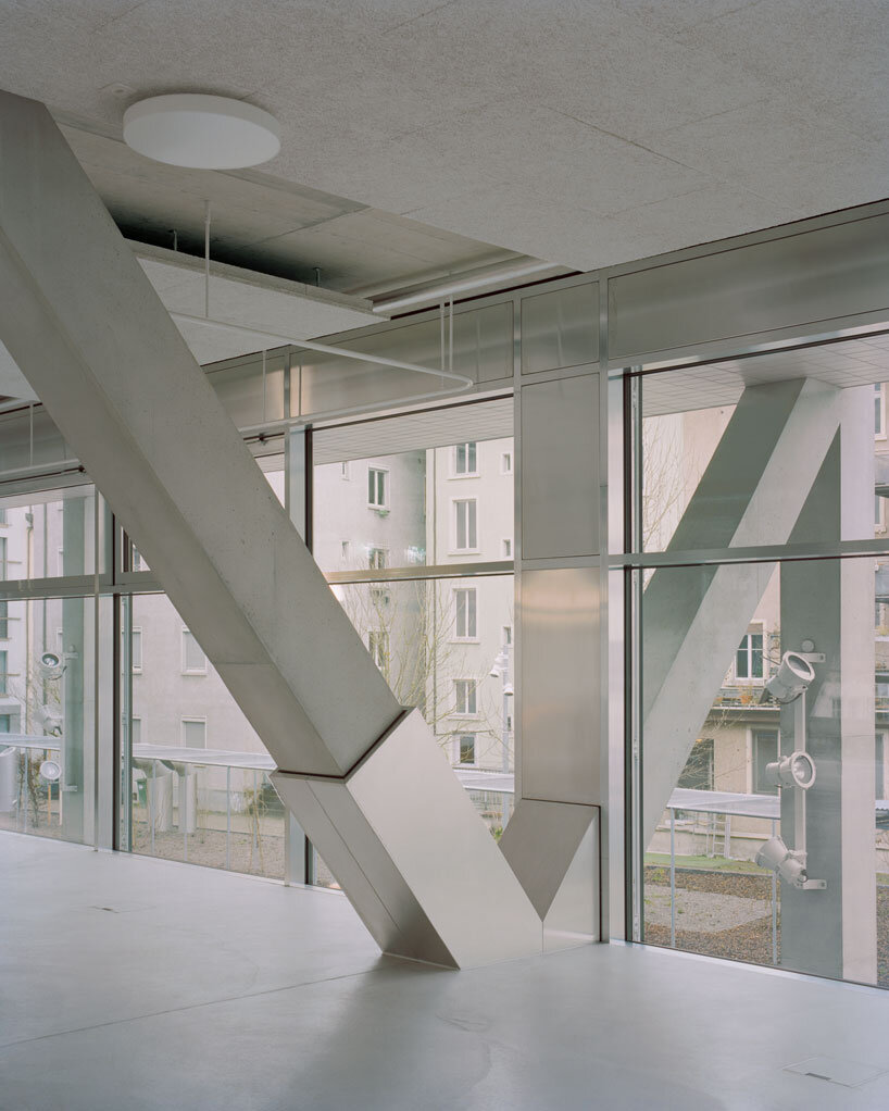 elevated concrete truss frame forms vocational school for construction trades in zurich
