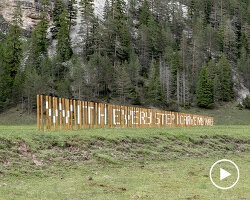 hundreds of wooden poles make up anamorphic installation spreading across italian hillside