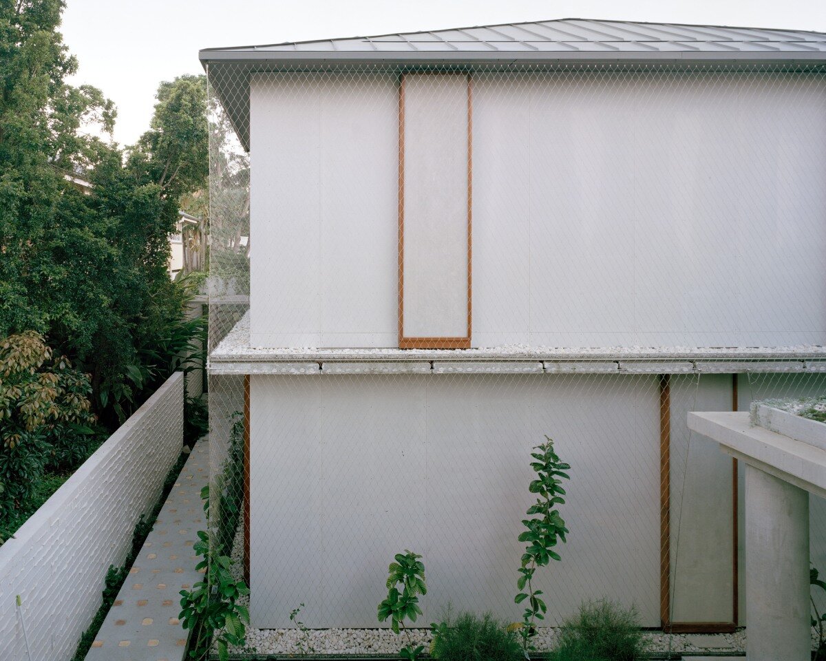 salvaged terracotta & metal nets enclose peter besley's ziggurat-topped australian house