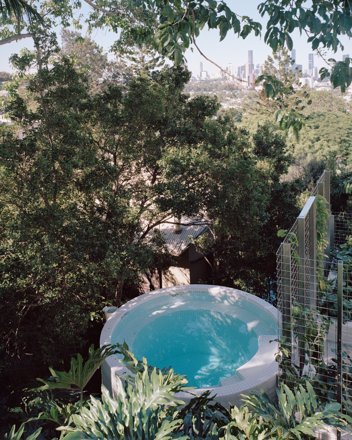 salvaged terracotta & metal nets enclose peter besley's ziggurat-topped australian house