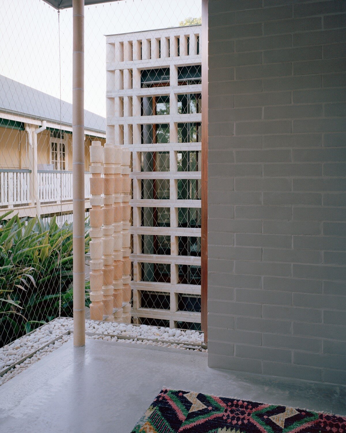 salvaged terracotta, bricks, and metal nets wrap around peter besley's australian house