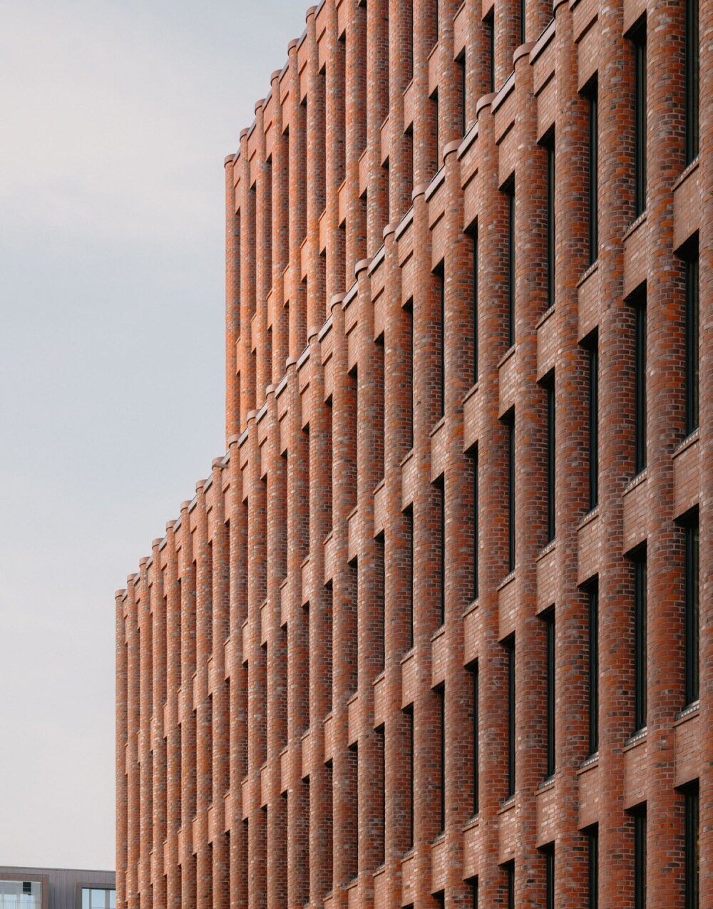semi-circular brick columns clad christ & gantenbein's hamburg complex in rhythmic pattern