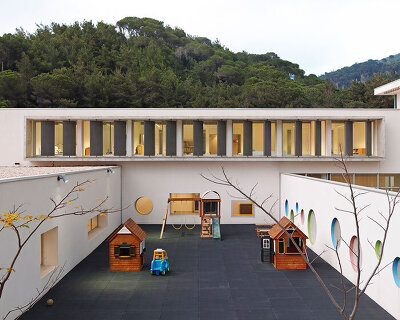 circular colored openings pierce through concrete facade of school extension in lebanon