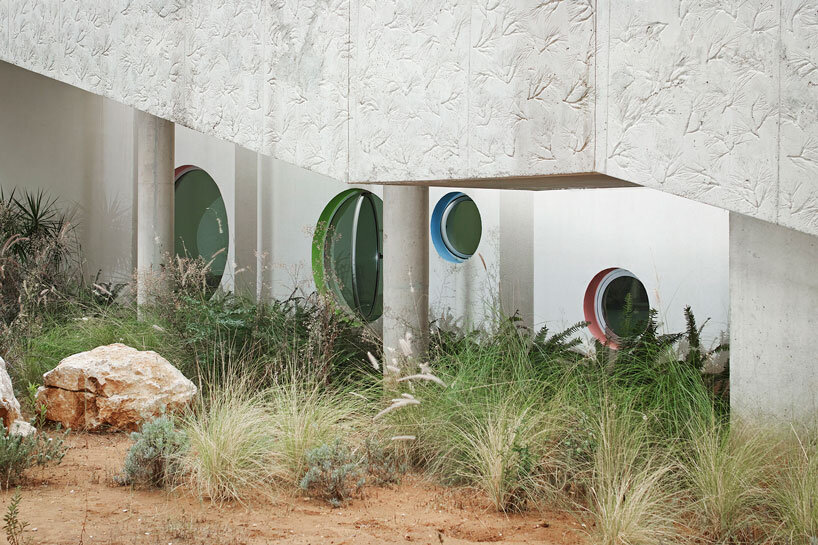 circular colored openings pierce through concrete facade of school extension in lebanon