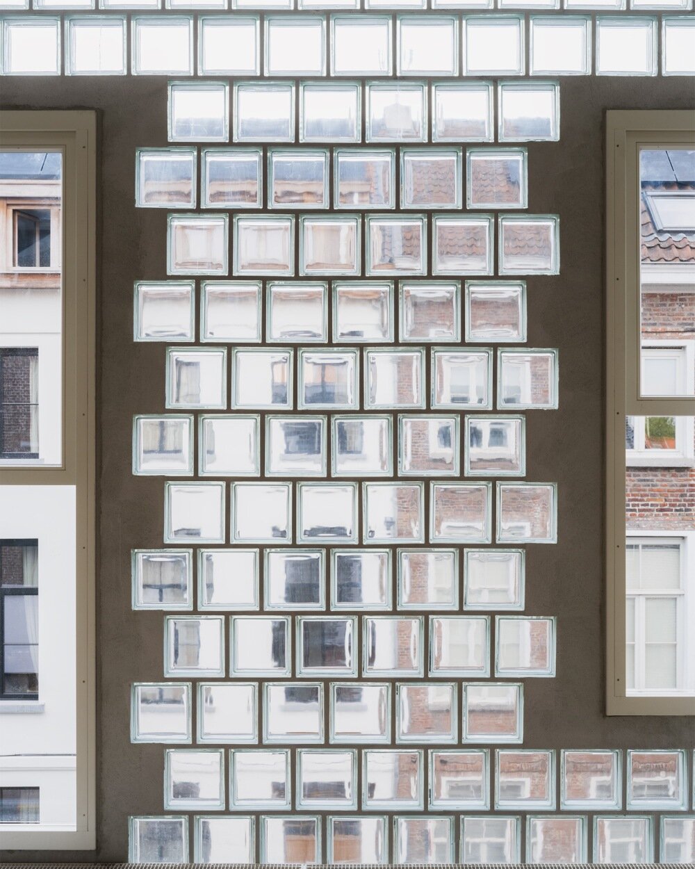 delmulle delmulle's gradient brick facade shifts from terracotta to glass in belgium house