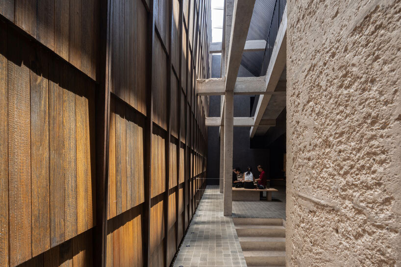 light and rain pour through internal courtyard within monochrome dessert shop in indonesia