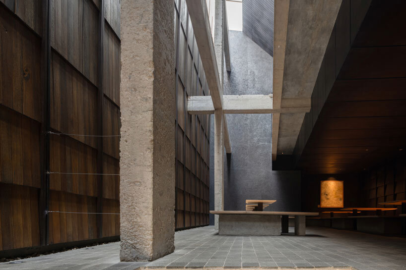 light and rain pour through internal courtyard within monochrome dessert shop in indonesia