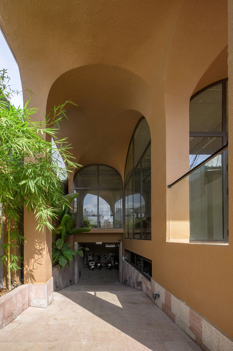 mixed-use unit's curved and vaulted volumes by room+ shape vertical garden in vietnam