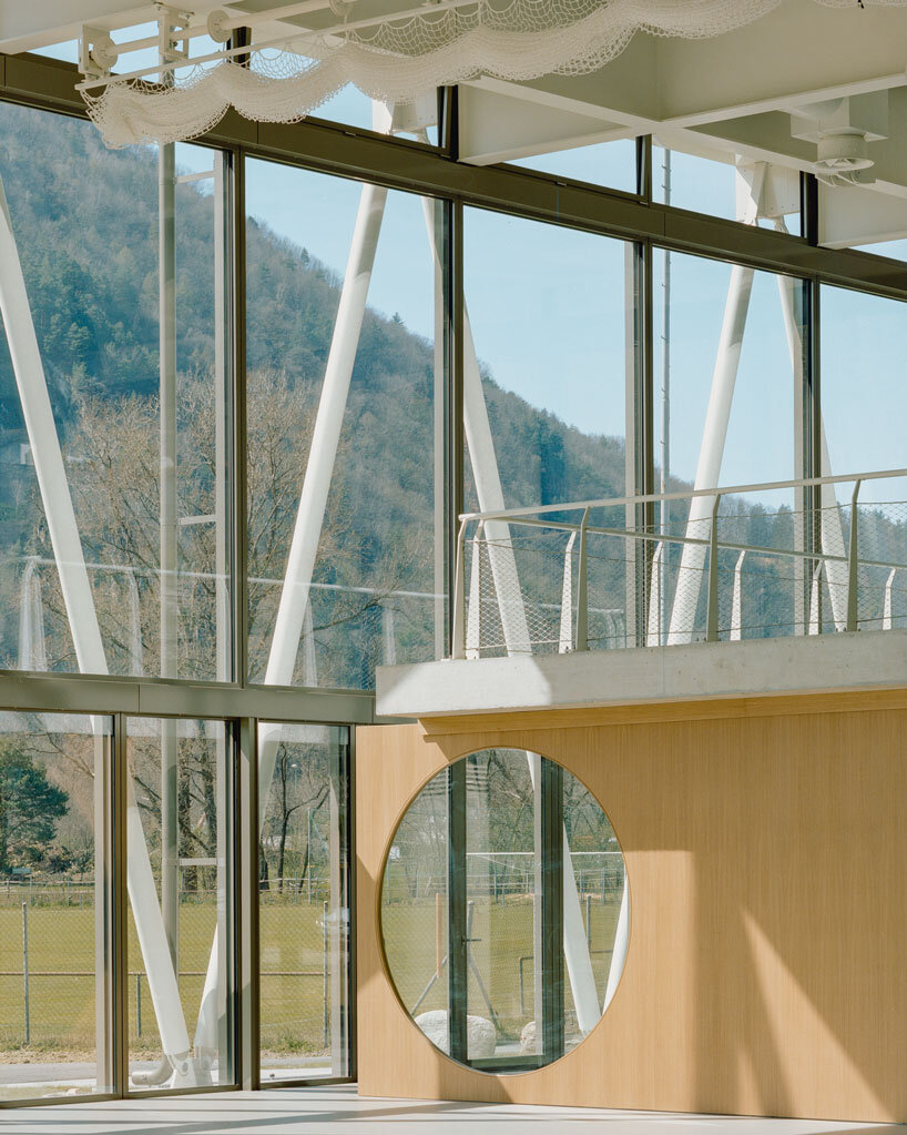 lattice of beams enfolds multipurpose gymnasium's facade in switzerland by demattè fontana