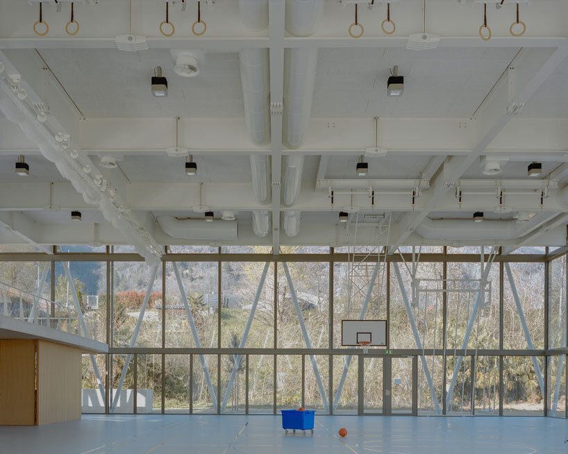 lattice of beams enfolds multipurpose gymnasium's facade in switzerland by demattè fontana