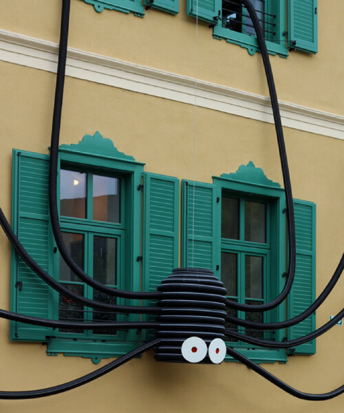 moradavaga's spider sprawls across facade in italy, reminiscent of an old-school string phone
