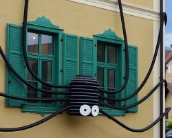moradavaga's spider sprawls across facade in italy, reminiscent of an old-school string phone