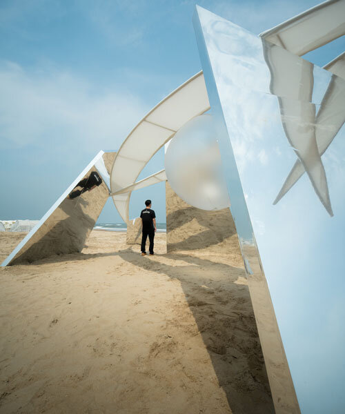 two suspended white wings float around luminous central sphere for oas/s-nest installation
