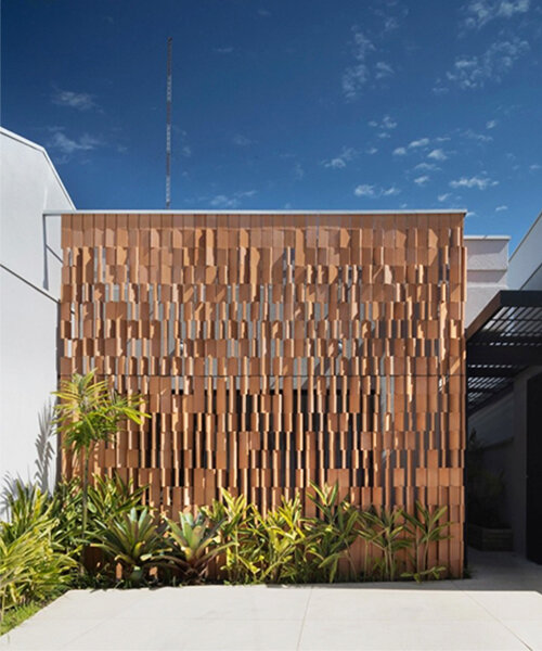 rhythmic terracotta screen filters light and privacy at vertentes arquitetura's otus clinic in brazil