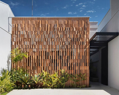 rhythmic terracotta screen filters light and privacy at vertentes arquitetura's otus clinic in brazil