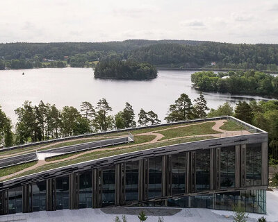 snøhetta's wendelstrand lakehouse resembles a moss-covered spine in sweden