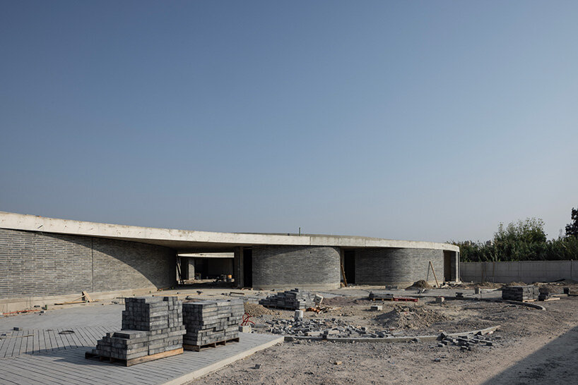 sordo madaleno embeds circular school into volcanic terrain at the foot of mexican pyramid