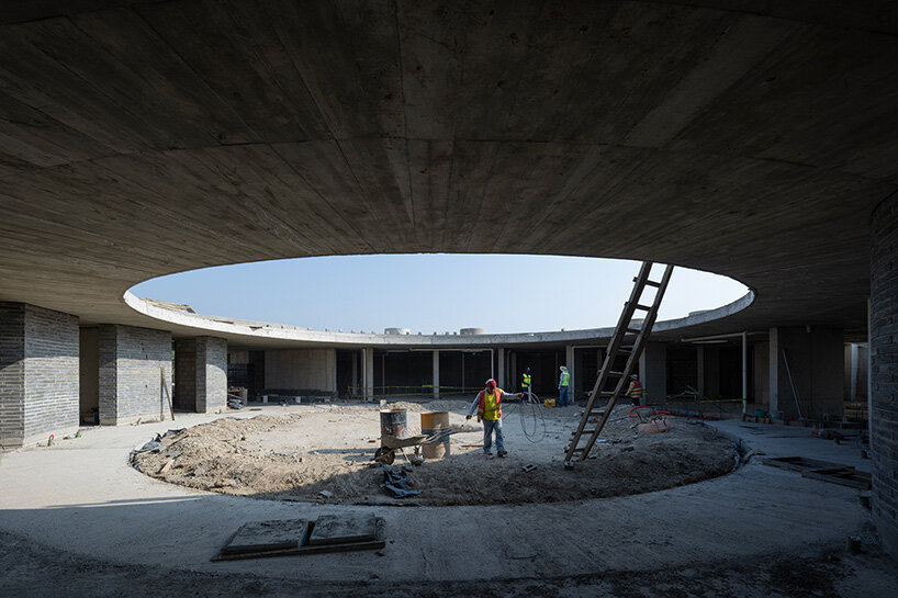 sordo madaleno embeds circular school into volcanic terrain at the foot of mexican pyramid