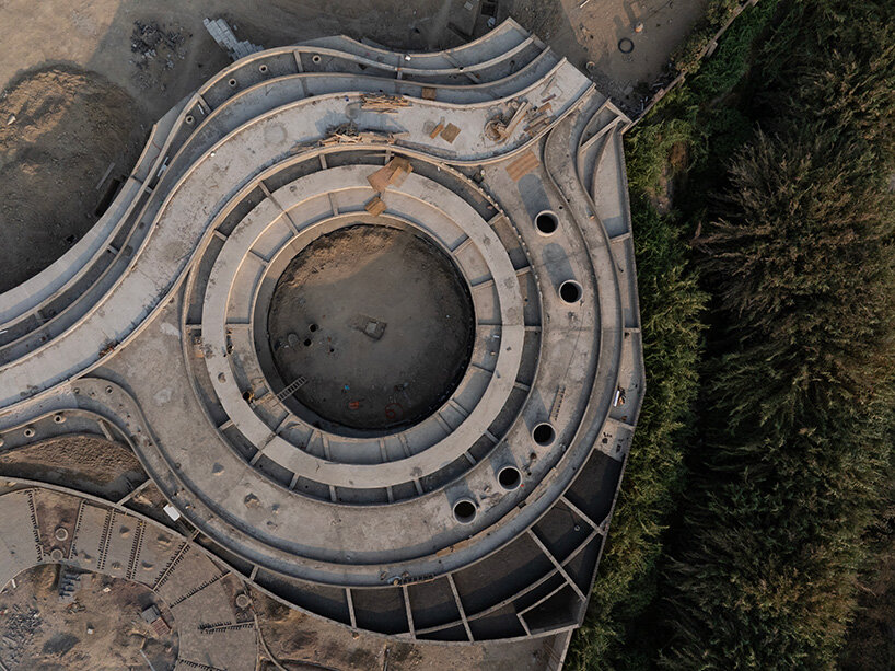 sordo madaleno embeds circular school into volcanic terrain at the foot of mexican pyramid