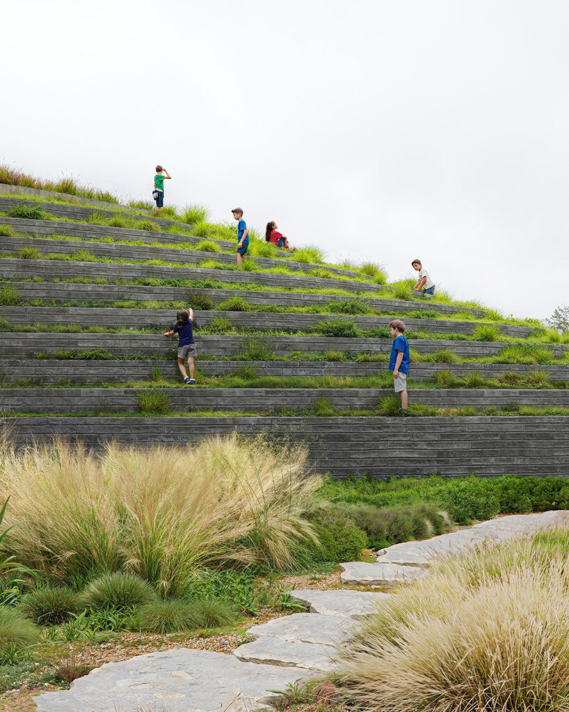 sordo madaleno embeds circular school into volcanic terrain at the foot of mexican pyramid