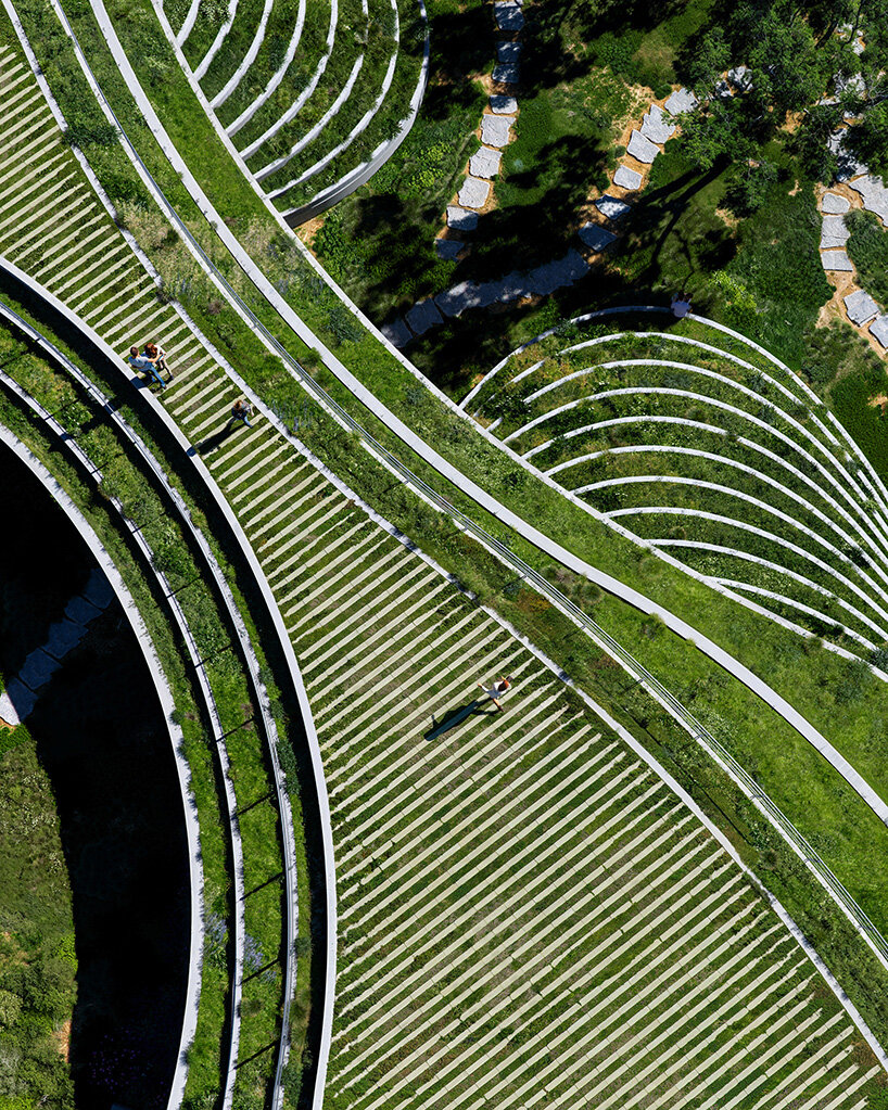 sordo madaleno embeds circular school into volcanic terrain at the foot of mexican pyramid