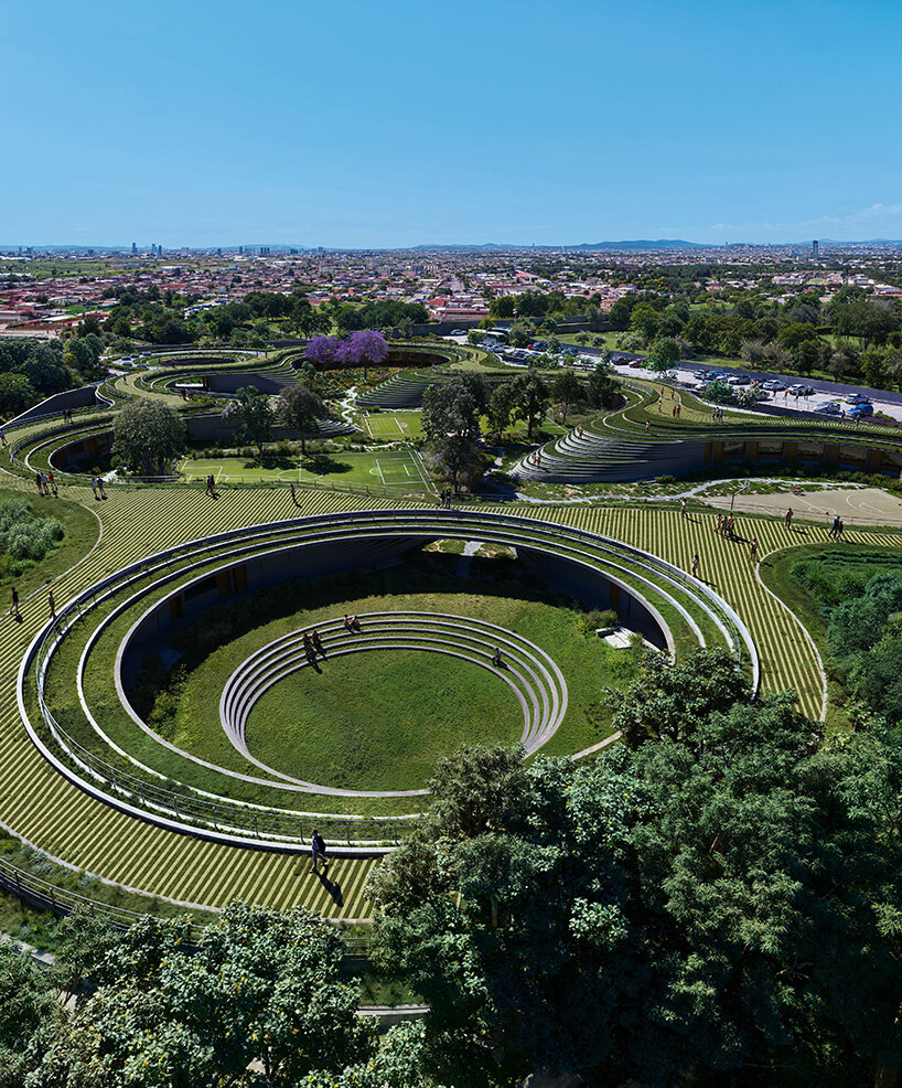 sordo madaleno embeds circular school into volcanic terrain at the foot of mexican pyramid