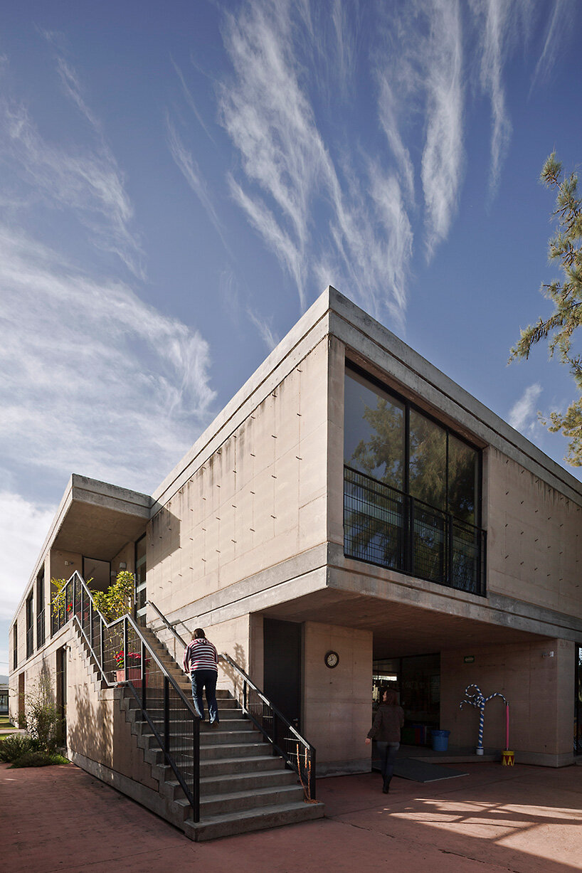tatiana bilbao shapes rammed earth preschool in mexico around central tree