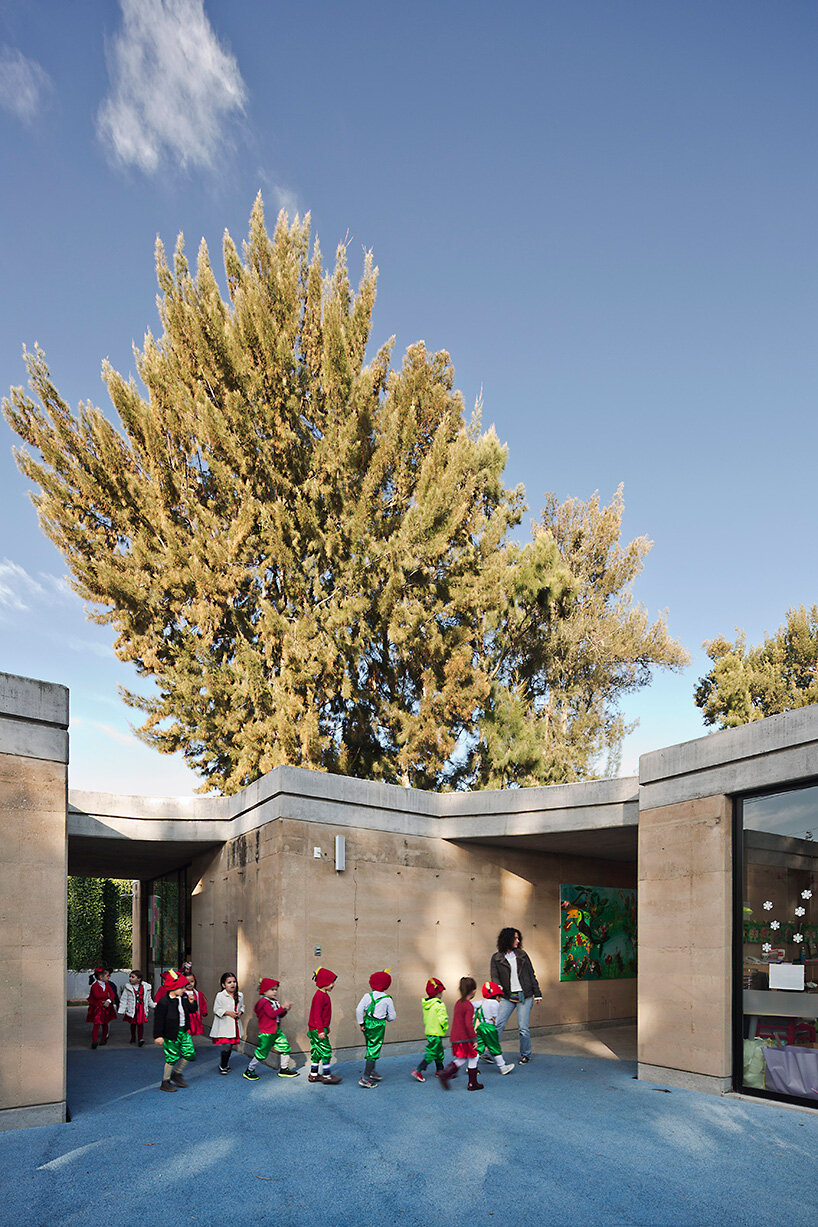 tatiana bilbao shapes rammed earth preschool in mexico around central tree