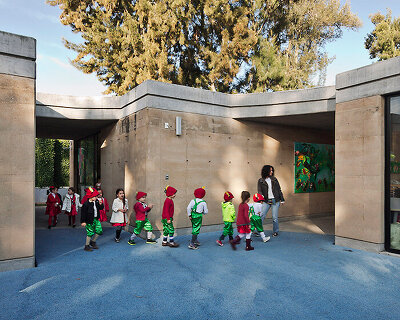 tatiana bilbao shapes rammed earth preschool in mexico around central tree