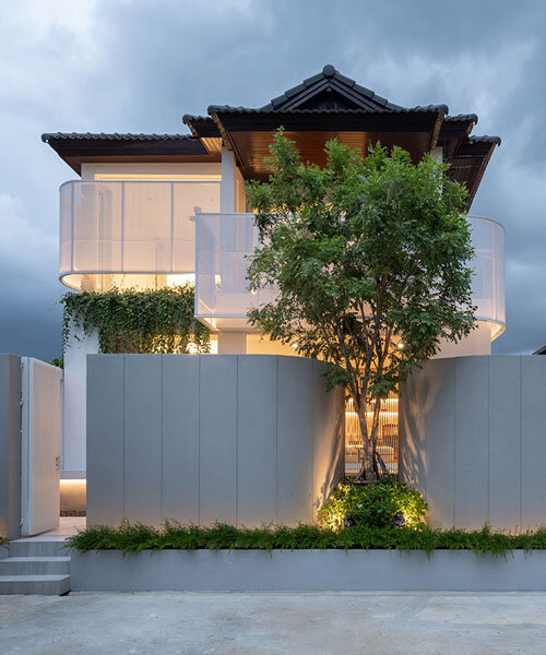 curved textile facades wrap reborn house in bangkok village emitting soft glow