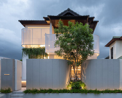 curved textile facades wrap reborn house in bangkok village emitting soft glow