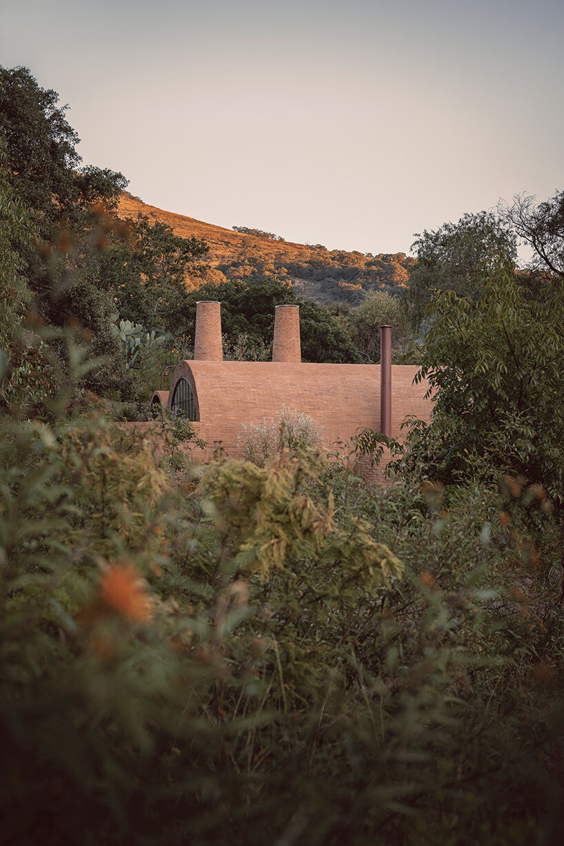 GOMA tucks vaulted cabin into mexican landscape with twin brick towers rising above