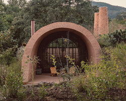 GOMA tucks vaulted cabin into mexican landscape with twin brick towers rising above